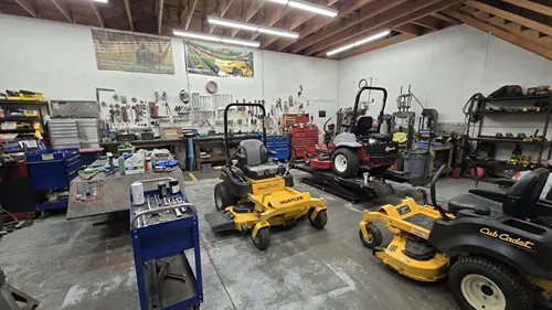 Professional lawn mower service bay with multiple zero-turn mowers